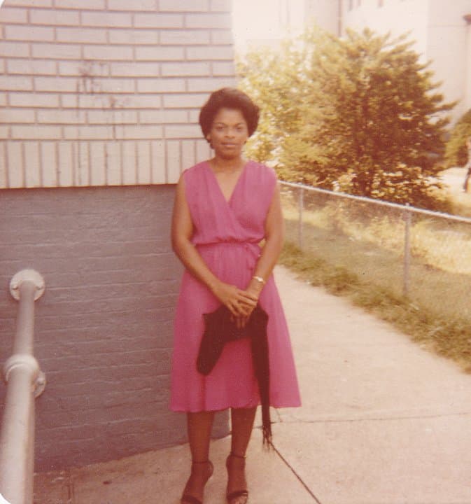 Celia in a pink dress by the fence