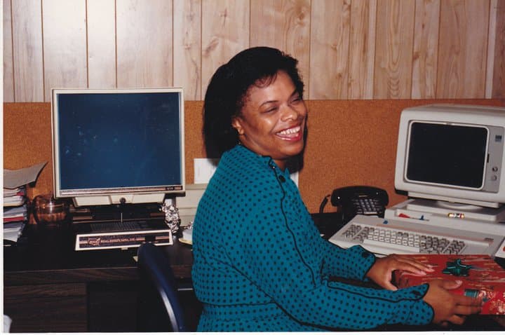 Celia smiling at an office desk