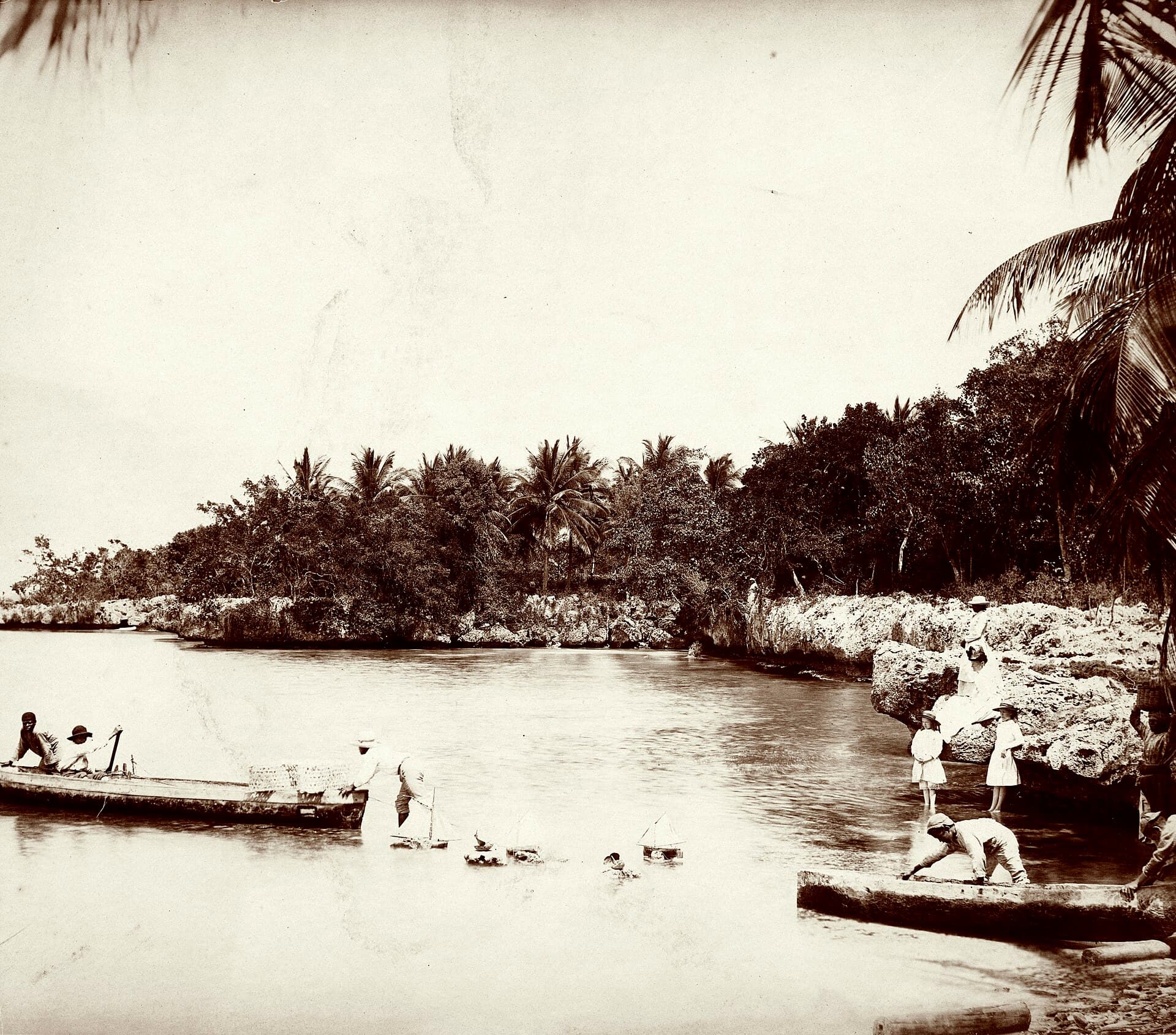 A quiet cove at Runaway Bay, St Ann, around 1890, with canoes and children at the water's edge